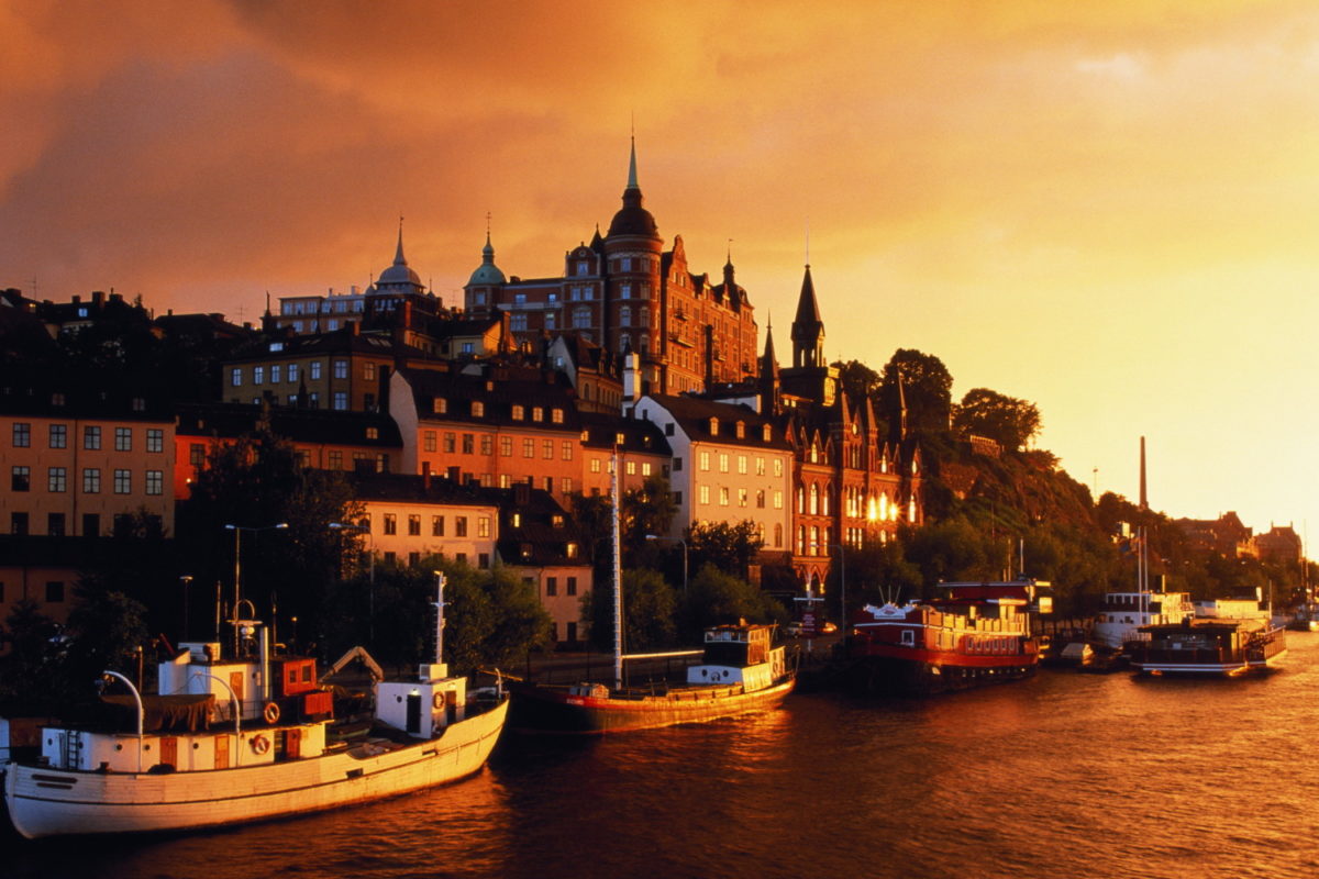 Sweden, Stockholm, Sodermalm, Lake Malaren, boats and town hall,sunset